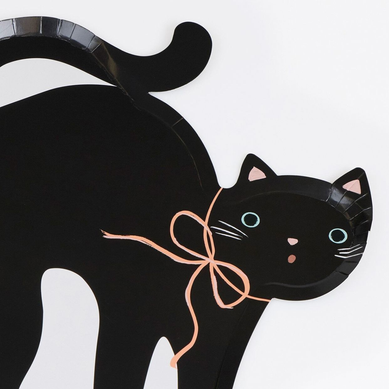 A black cat-shaped wall hanging or decoration made from a paper plate, with painted blue eyes, pink nose and inner ears, white whiskers, and a peach ribbon bow around its neck, shown on a light gray background.