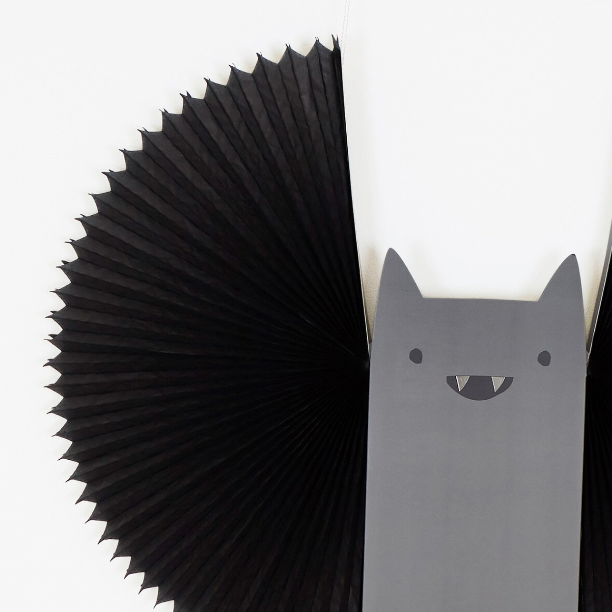 A black accordion-style pleated bat on a white background.