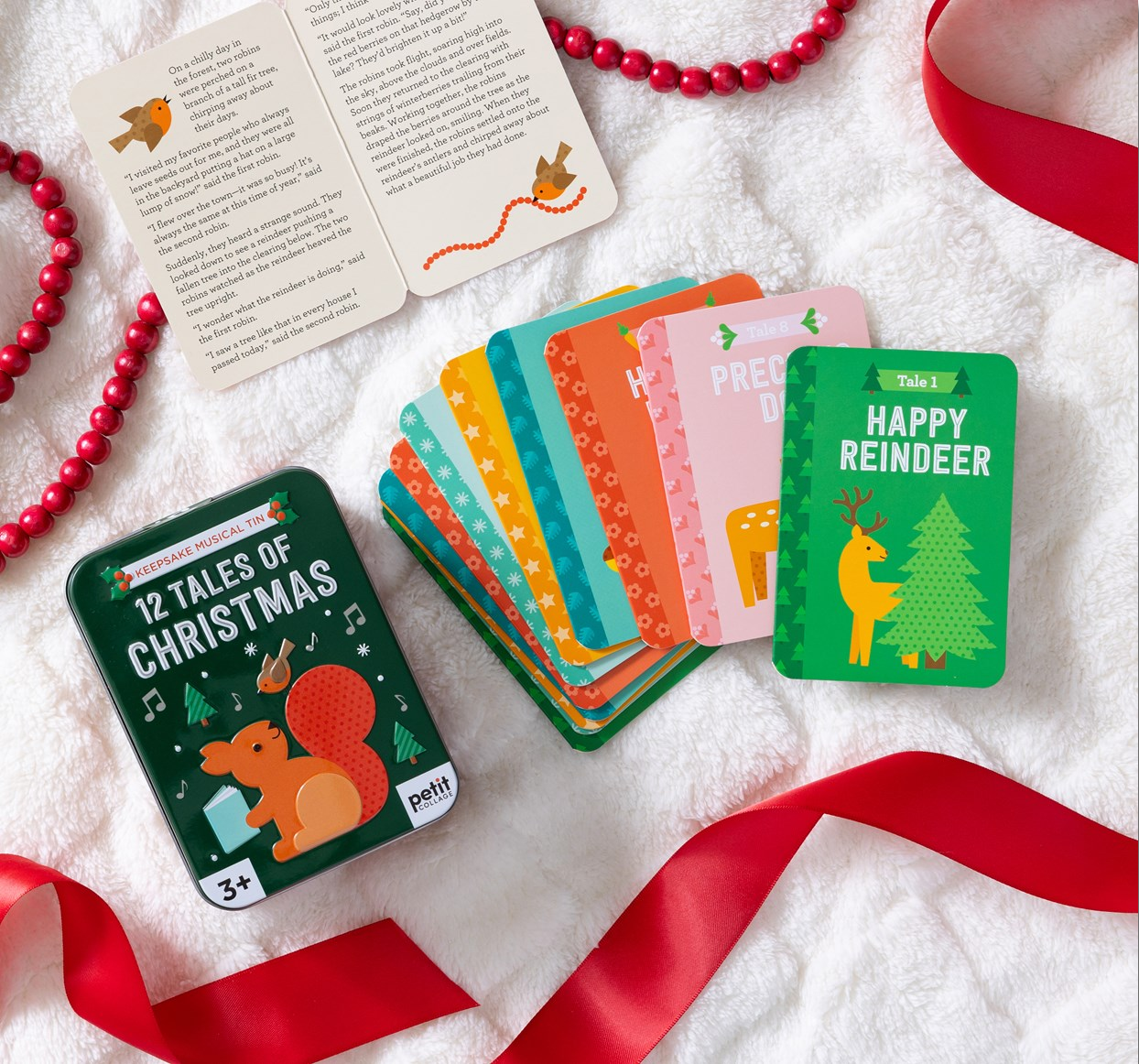 Set of Christmas-themed cards on a white surface with red ribbons.