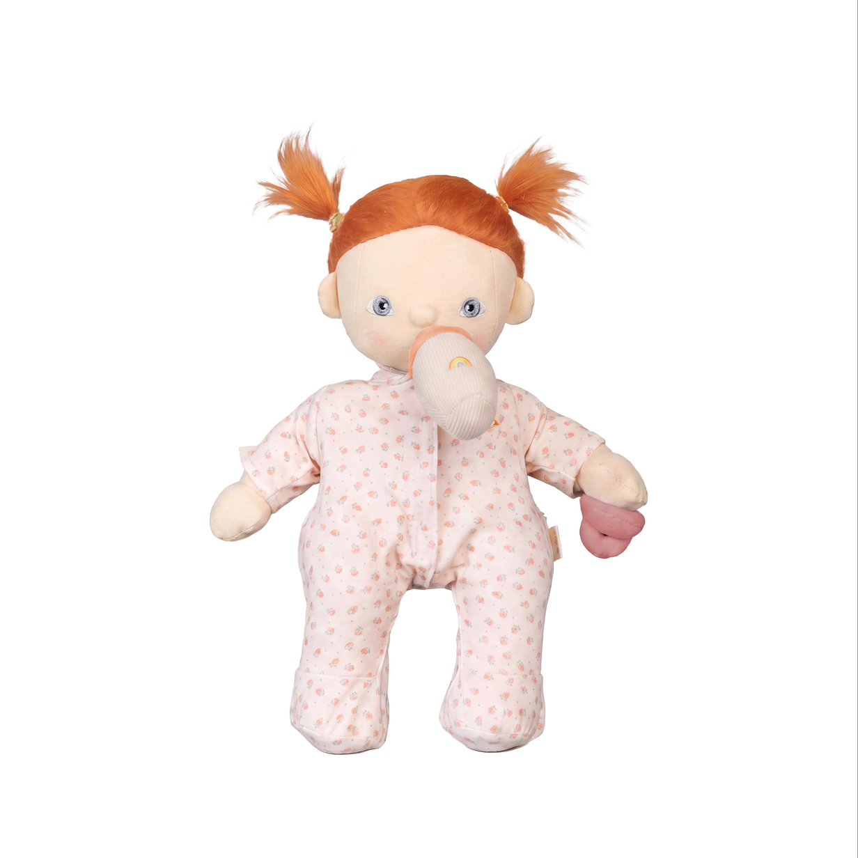 A plush baby doll with orange hair in pigtails, wearing a pale pink patterned footed romper, on a plain white background.