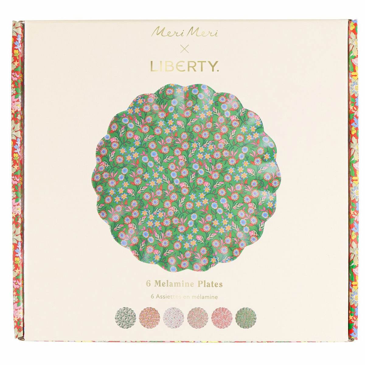 Meri Meri x Liberty 6-piece Melamine Plates set in floral green, pink, and blue, presented in its cream-colored packaging with a scalloped floral border.