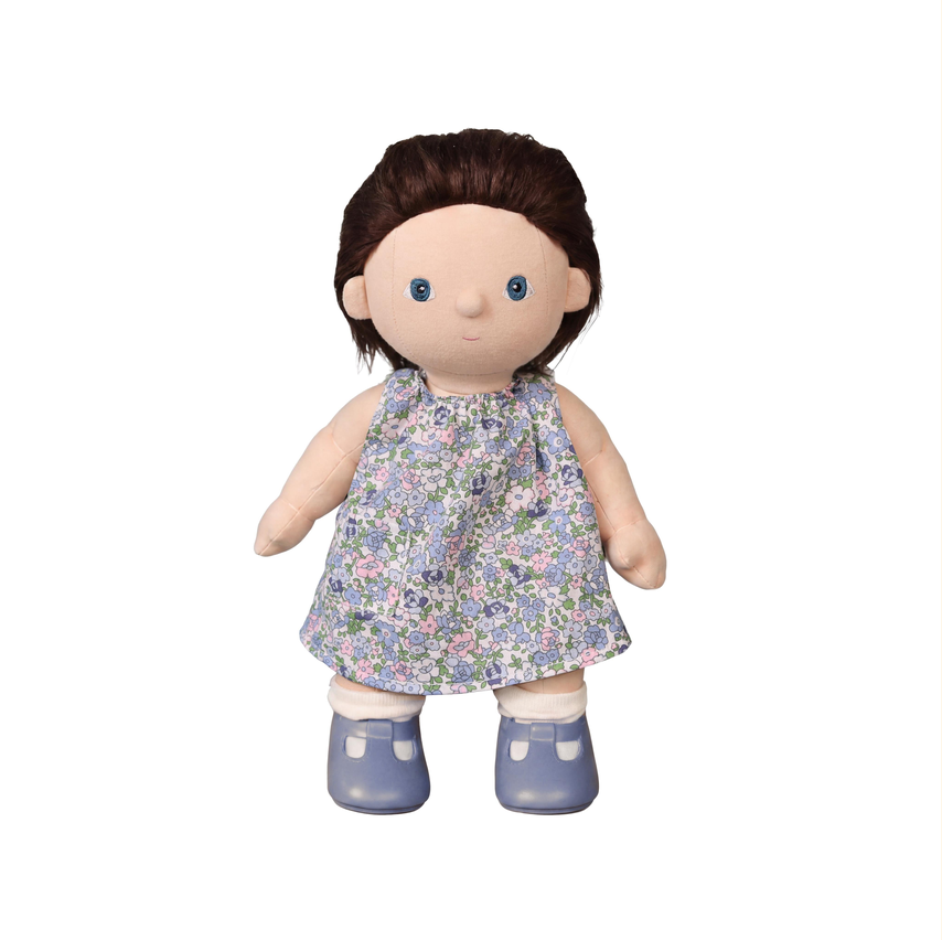 A doll with brown hair, a beige face and arms, wearing a sleeveless floral dress in blue, pink, and white, with blue shoes, isolated on a white background.