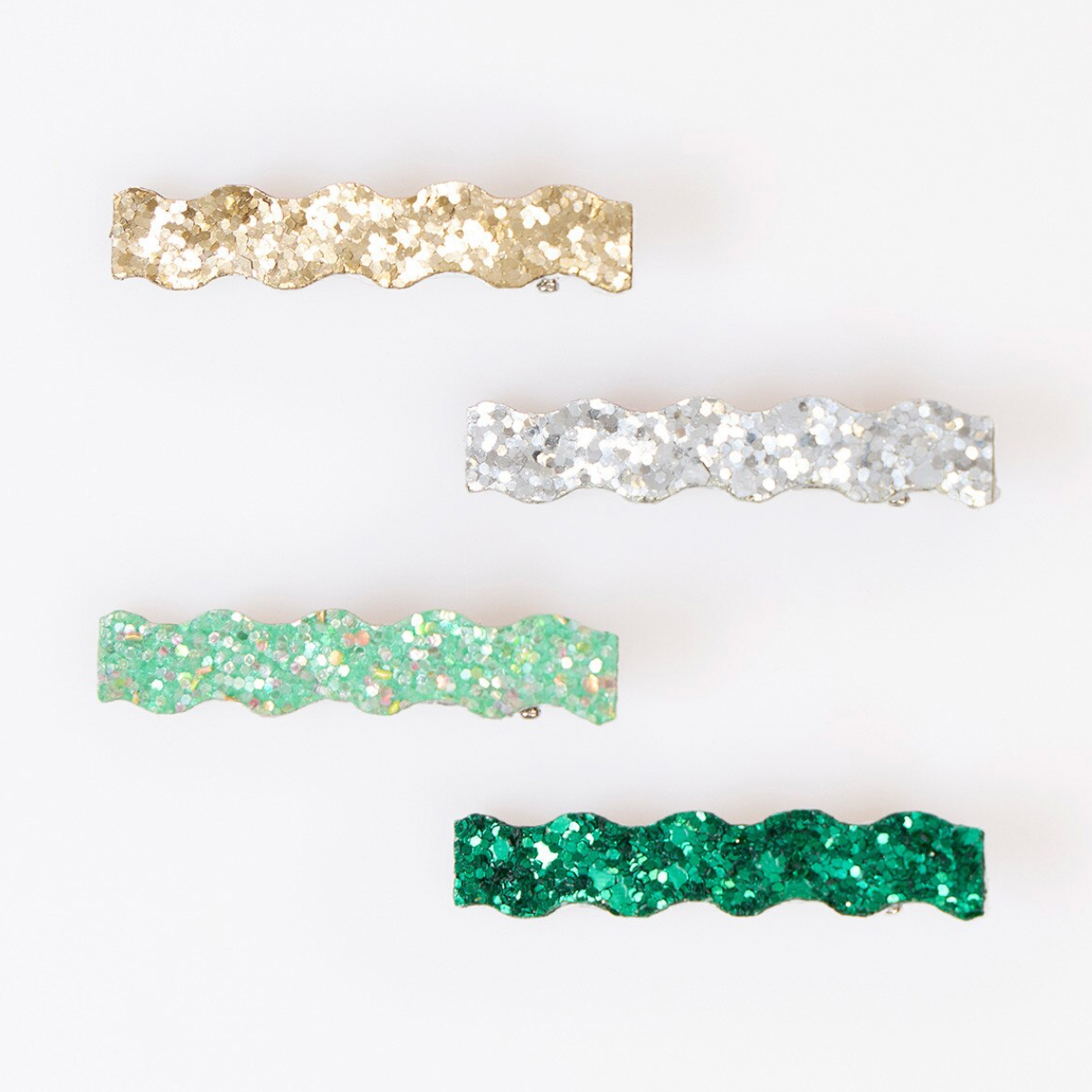 Four wavy glitter hair clips in gold, silver, mint green, and emerald green, displayed on a plain white background.