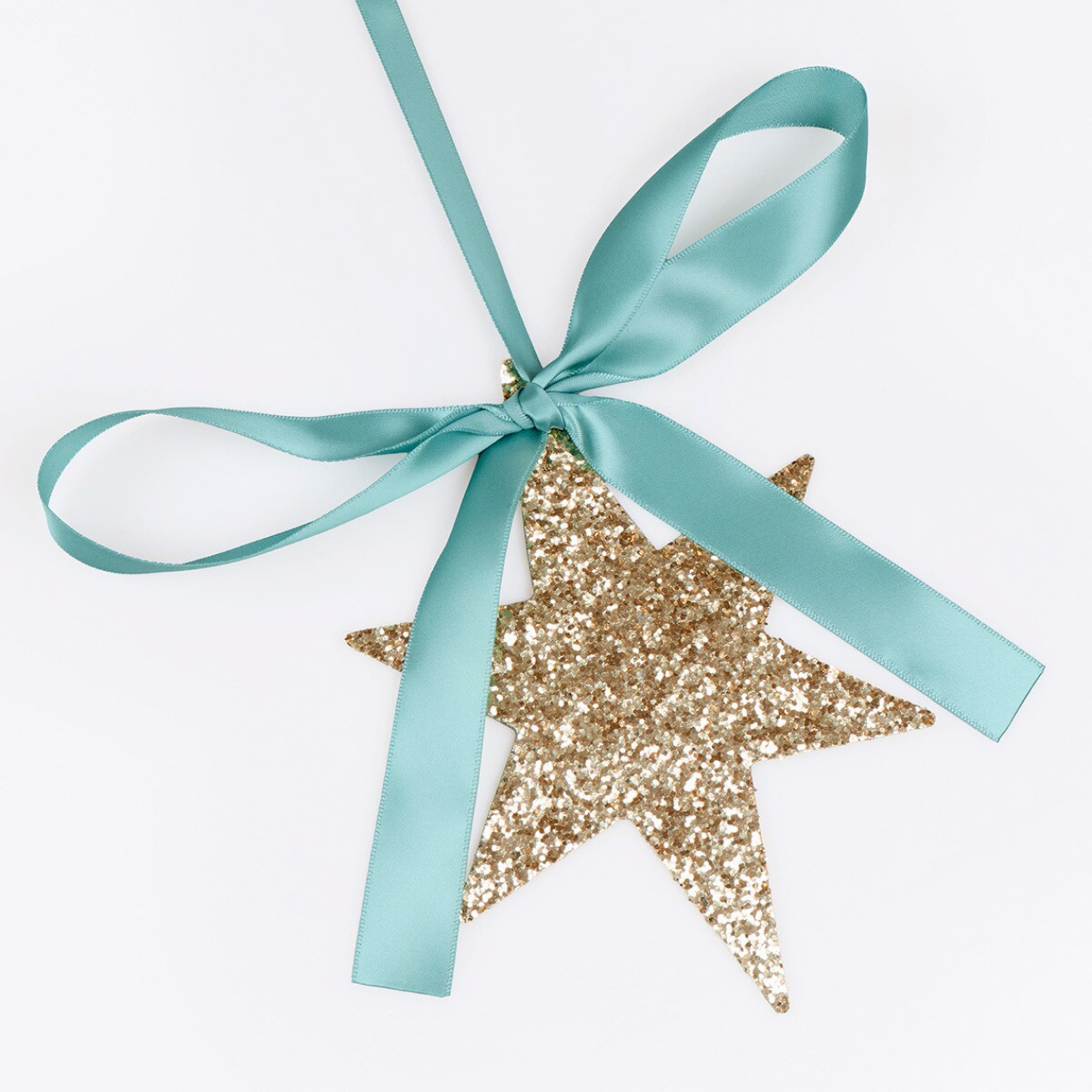 A gold glitter star ornament tied with a satin mint green ribbon on a white background.