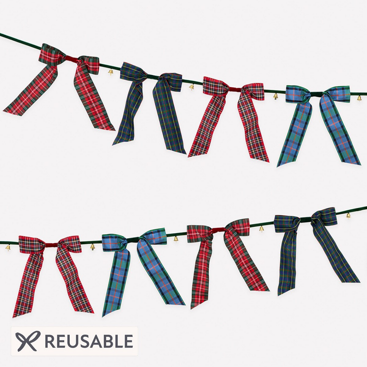 A reusable holiday garland banner with alternating plaid ribbon bows in red, navy, and green tartan patterns, strung along a dark green cord with small gold bells, shown on a light gray background with a 'REUSABLE' badge.