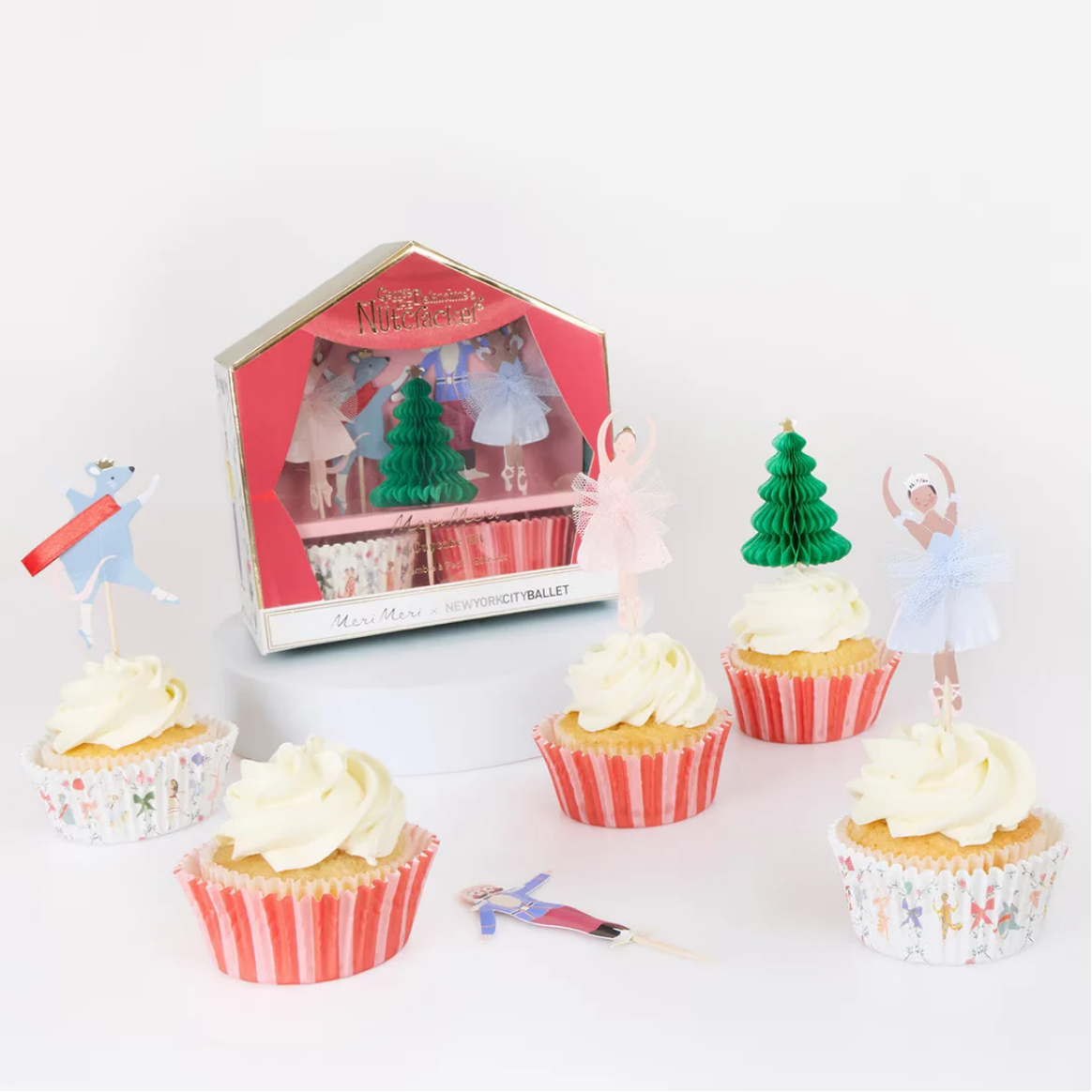 Cupcakes with decorative trees and ballerina figures on a white background