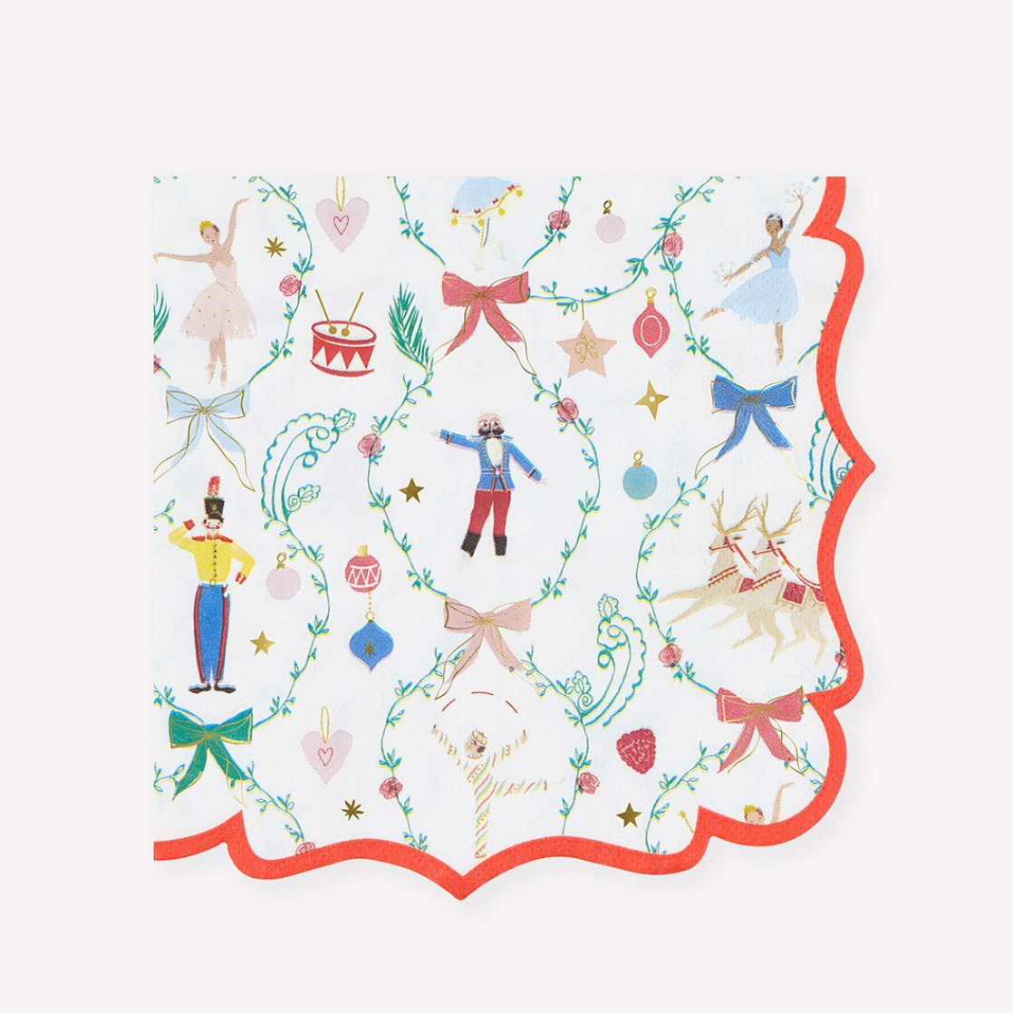 A square paper napkin with scalloped edges, featuring a festive holiday pattern of ballet dancers, a jester, a reindeer, ornaments, and ribbons on a white background with a red border.