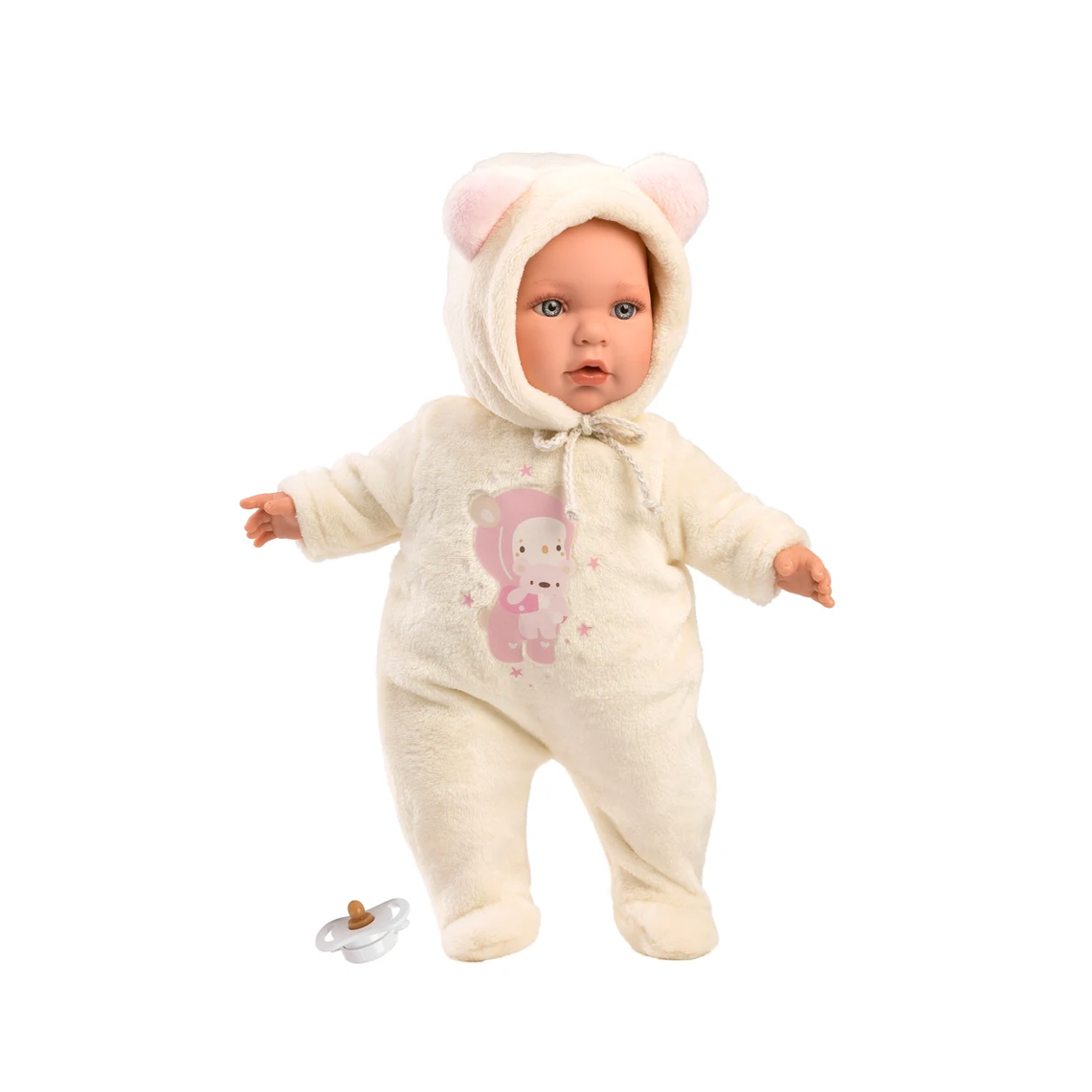 A baby doll wearing a cream-colored hooded footed romper with pink bear ears and a pink bear graphic on the front, shown on a white product page with a small pacifier beside it.