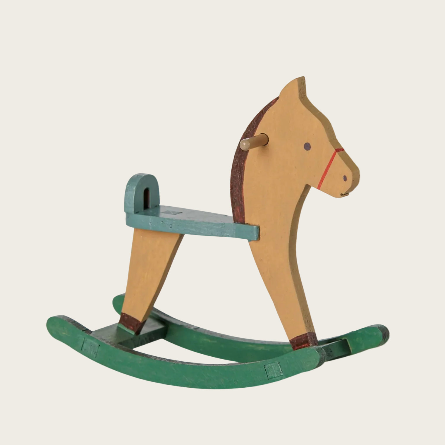 A wooden rocking horse toy shown on a website page, with a light natural wood body, dark green painted base and backrest, and a small red rope accent around the nose.
