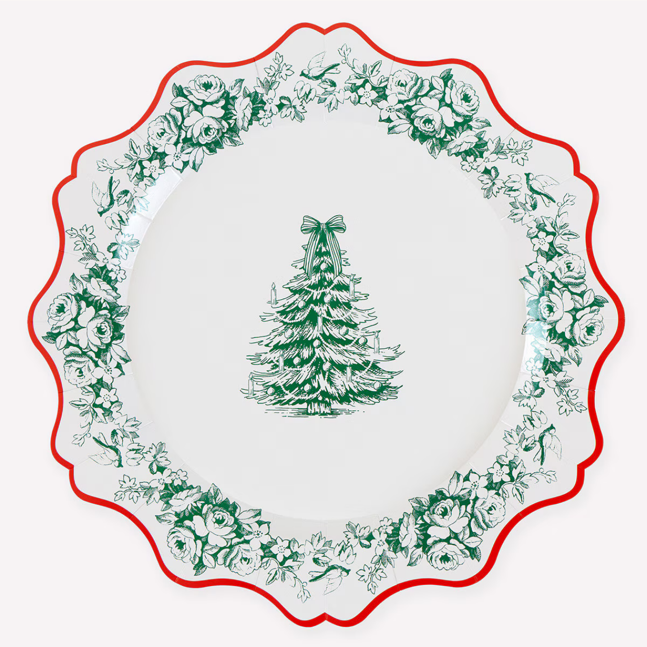 A white ceramic holiday plate with a scalloped rim, featuring a green Christmas tree motif in the center and a border of green floral and holly illustrations, accented by a red rim.