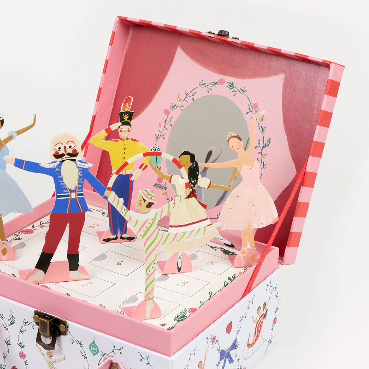 A pink and white wooden toy music box with a ballerina pop-up design, featuring colorful illustrated figures and a mirror on the inside lid, set against a plain white background.