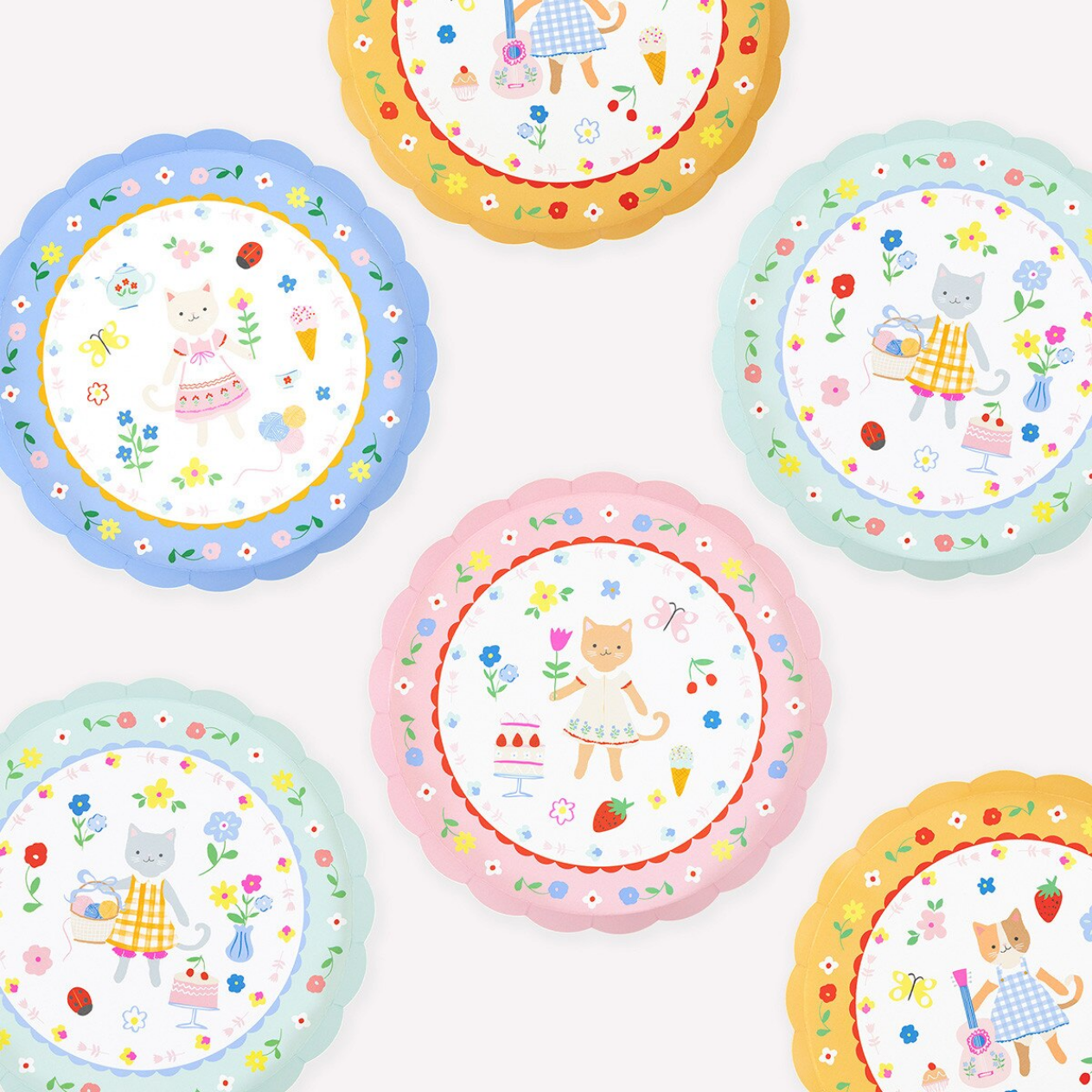 Set of colorful children's plates with cartoon characters and floral designs on a white background.