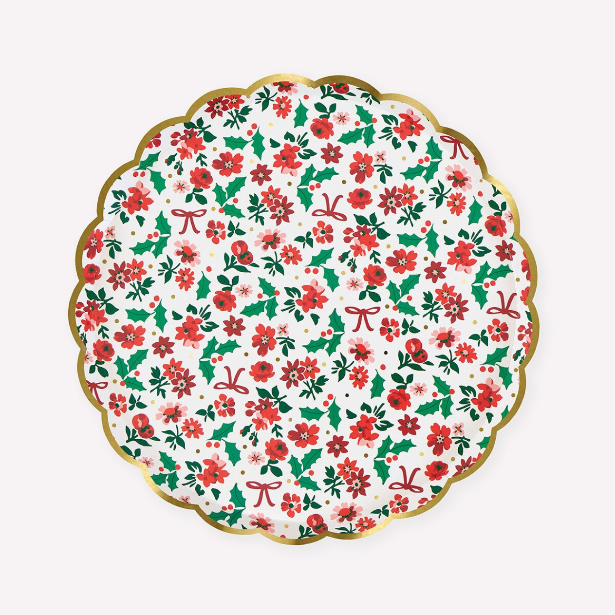 A scalloped paper plate featuring a festive Christmas pattern of red poinsettias, green holly leaves, and red bows on a white background, finished with a gold rim.