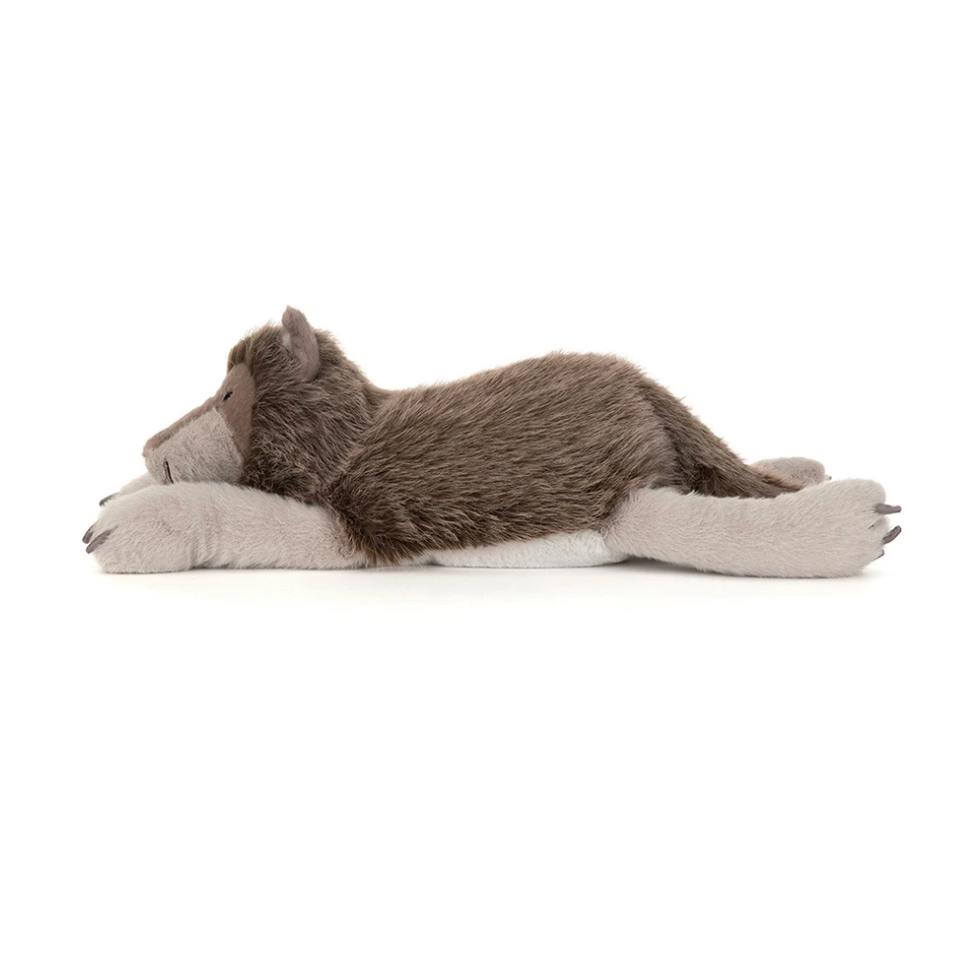 A plush stuffed wolf toy lying on its side, photographed against a plain white background. The wolf has brown and gray fur with a pale beige paws and snout.