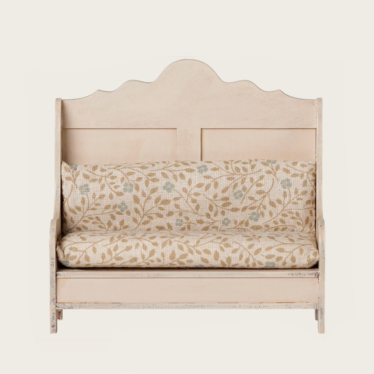A kitchen bench with a light wood frame and a printed cushion featuring a beige leaf pattern on a white background