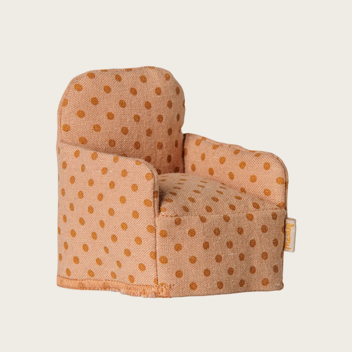An upholstered folding chair with a warm beige fabric and orange polka dots.
