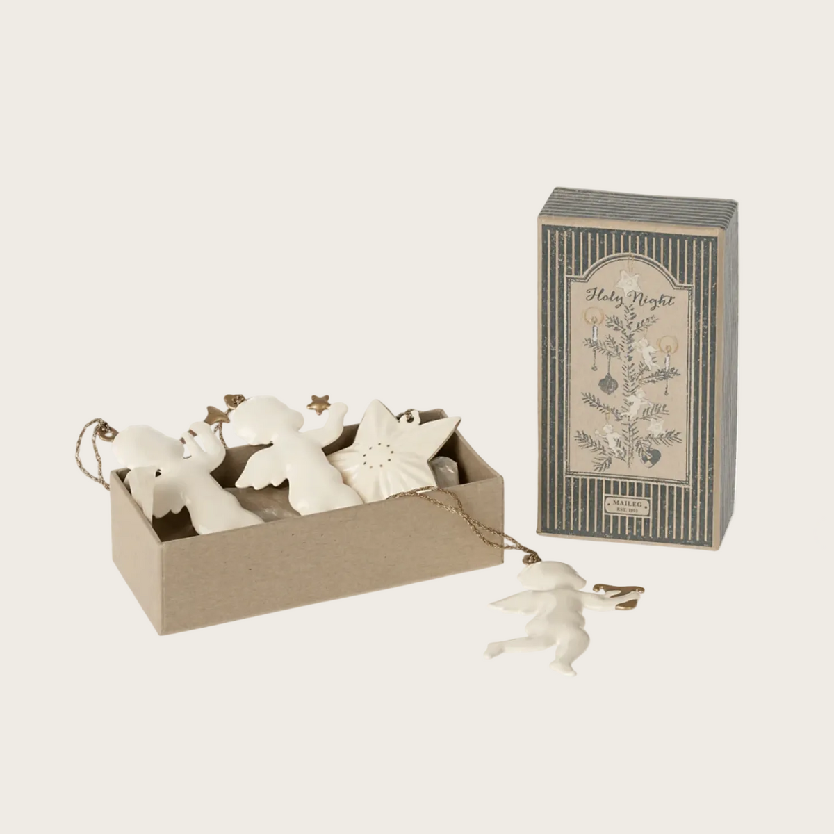 A product listing page showing a 2022 Holy Night ornament set in a beige box with white metal star and angel ornaments, alongside the product packaging box. 