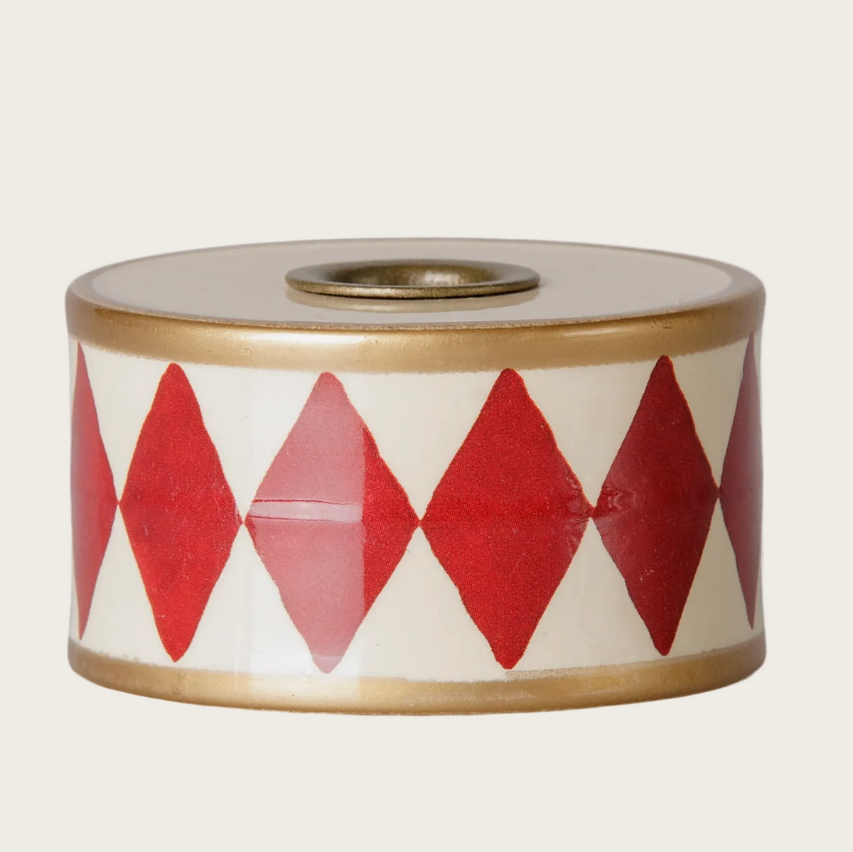 A candle holder drum featuring a white body with a red harlequin diamond pattern and a metallic gold rim.