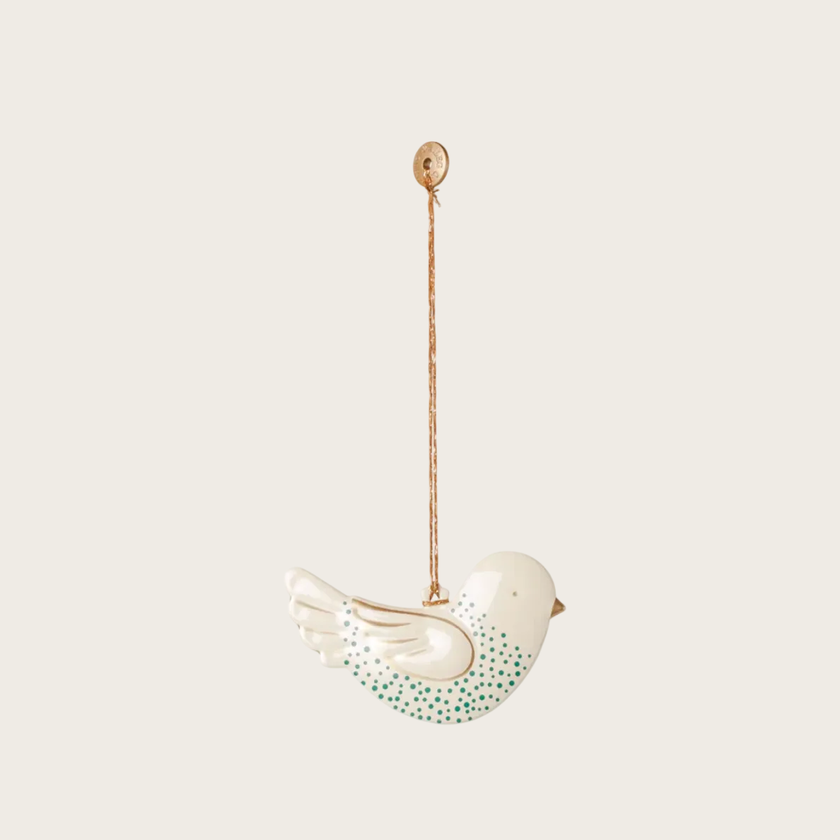 A hanging bird-shaped metal ornament in white with green dotted detailing on the body, suspended from a gold-toned loop against a plain light background.
