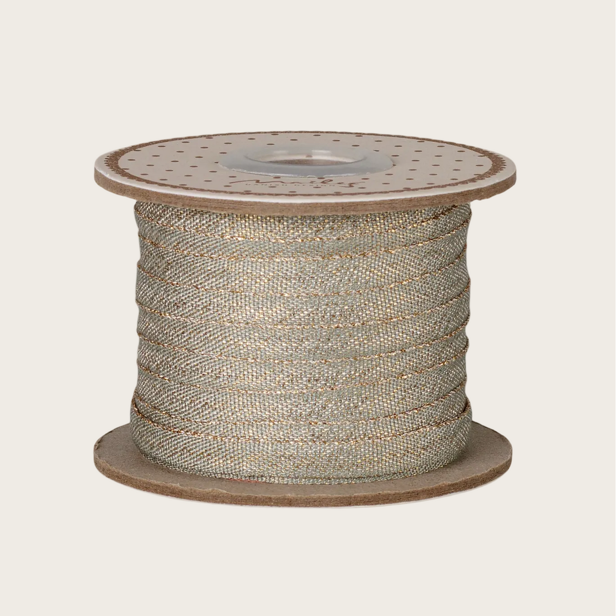 A spool of gold ribbon wound on a brown cardboard spool, set against a solid off-white background.