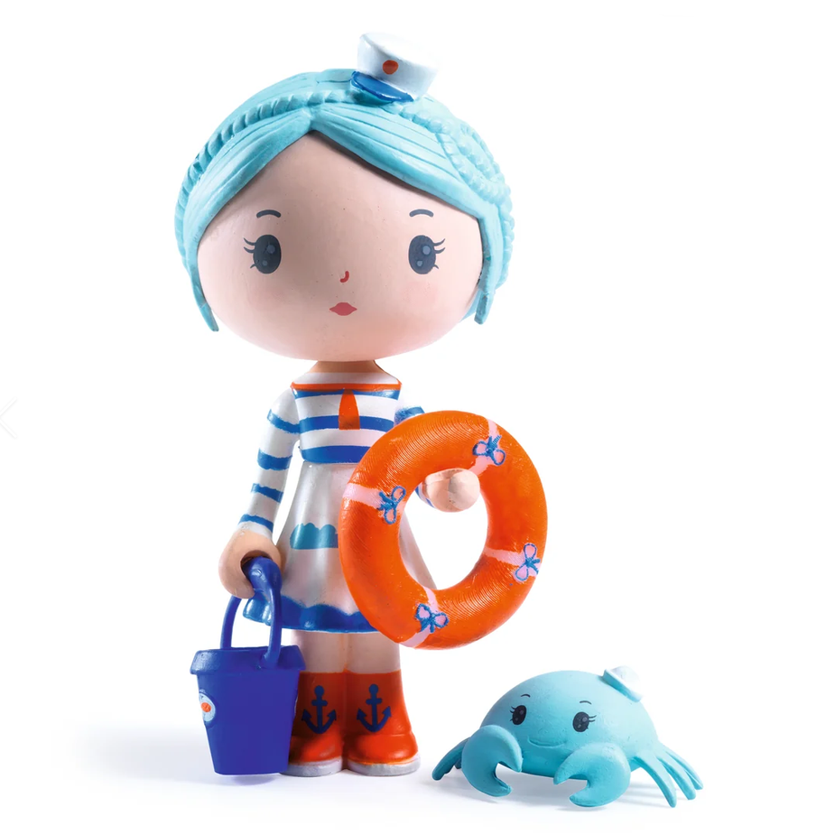 A cartoon-style nautical toy figure with light blue hair, a sailor dress, orange life ring, blue bucket, and a small blue crab toy on a plain white background.