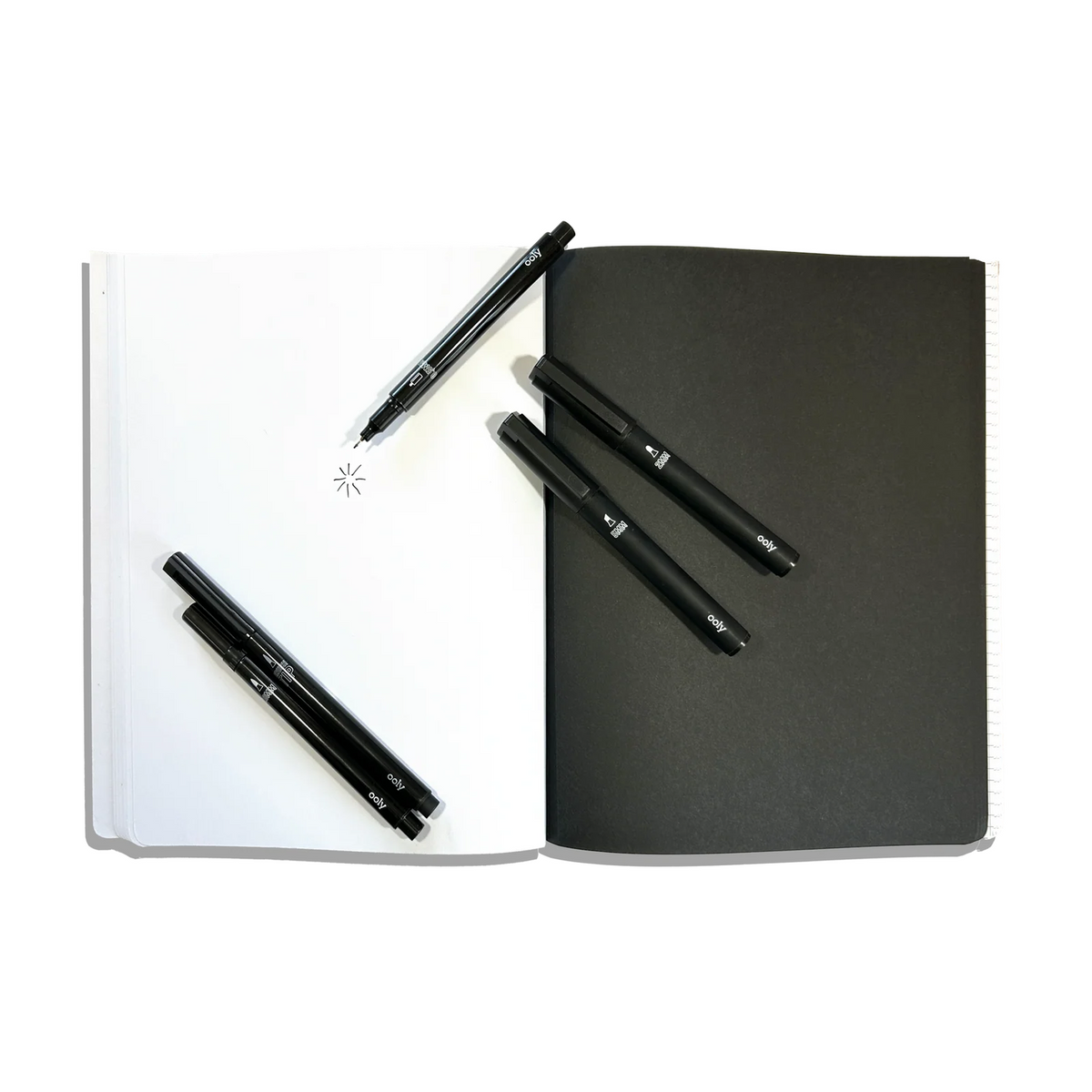 Black notebook with pens on a white background