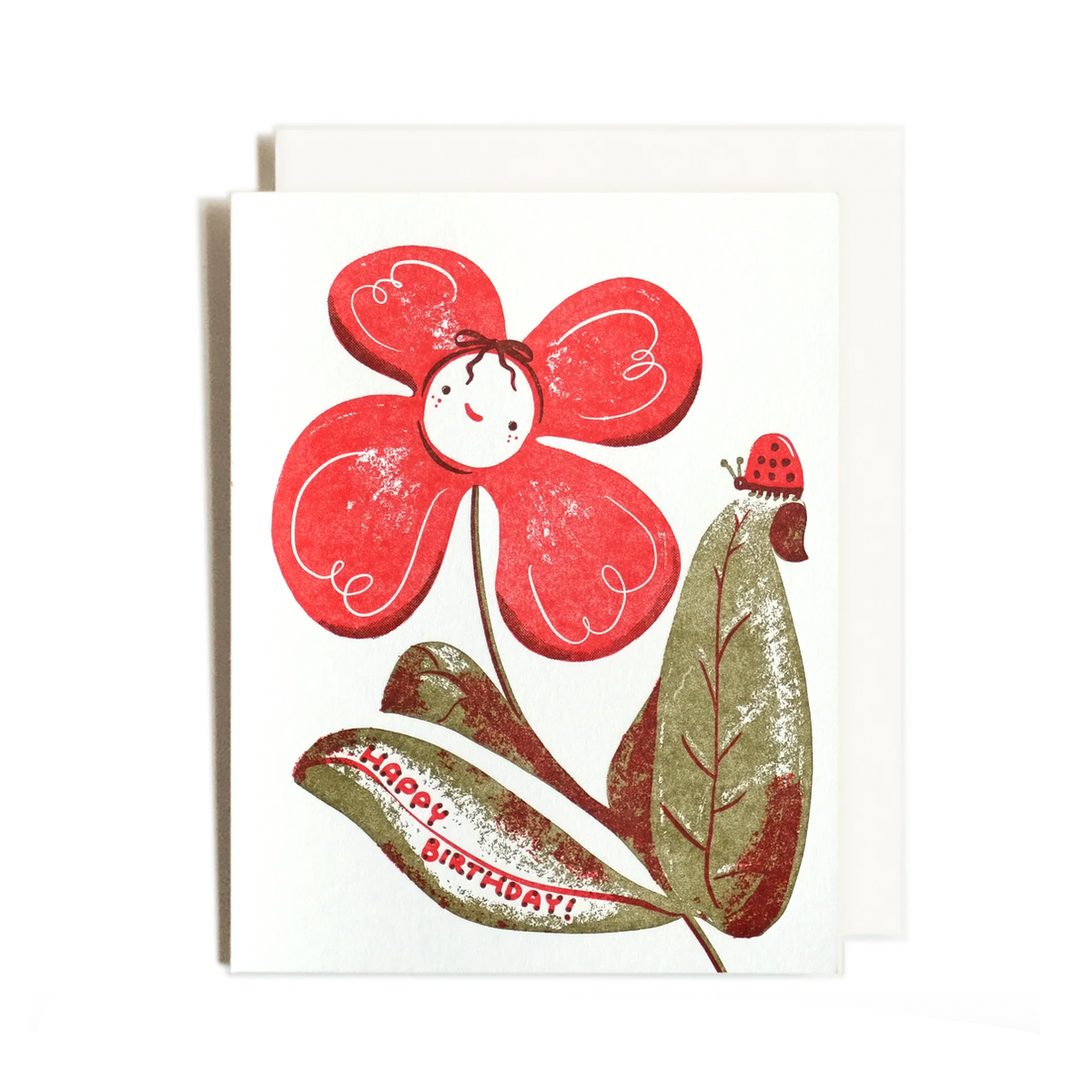 A greeting card featuring a red flower with a smiling face, green leaves, and a ladybug, shown on a white background with a computer monitor and desktop icons partially visible around the edges.