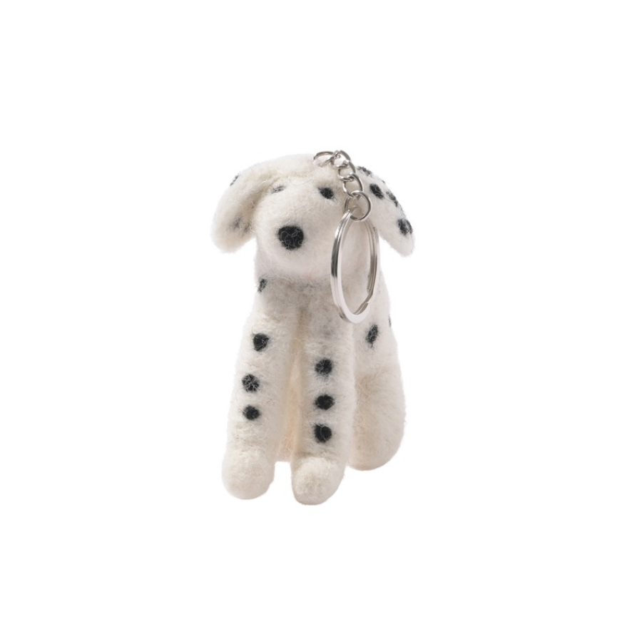 A small plush dog keychain shaped like a Dalmatian, made from white felt with black spots, attached to a silver metal split ring, on a plain white background.