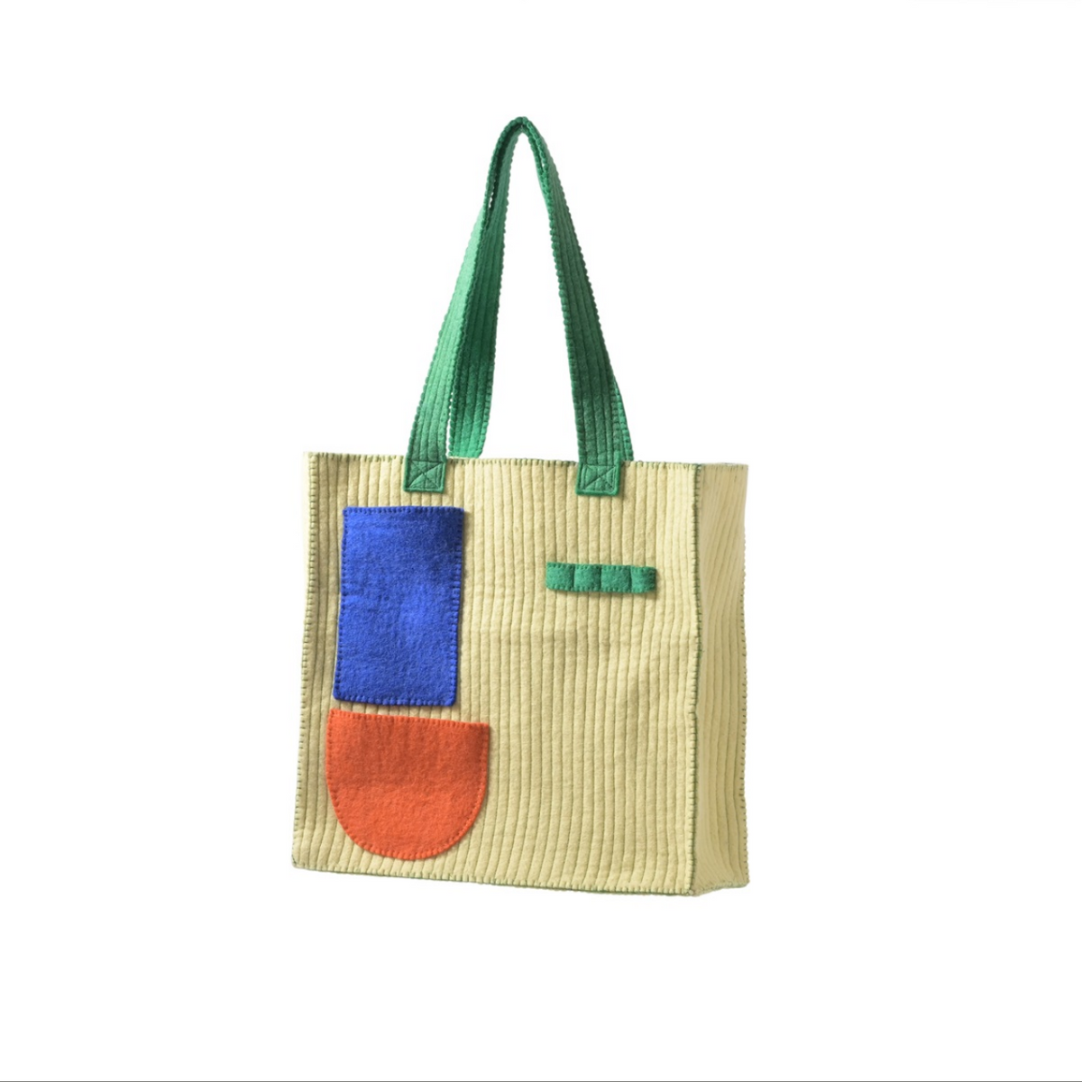 Tote bag with green handle, blue pocket, and orange patch on a white background