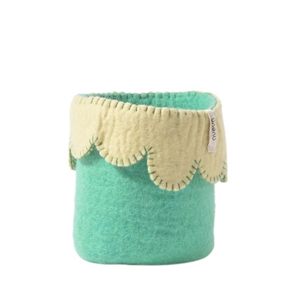 Green and beige fabric basket on a white background
