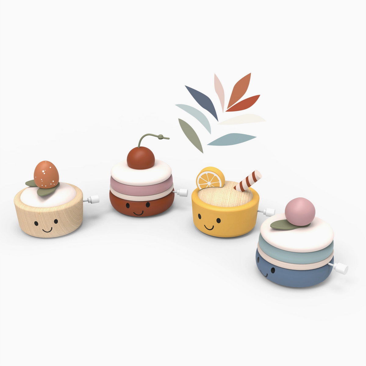 Four wooden wind-up toy desserts with smiling faces, each topped with different colors and small decorative details, arranged on a clean white background with a small leaf graphic above them.