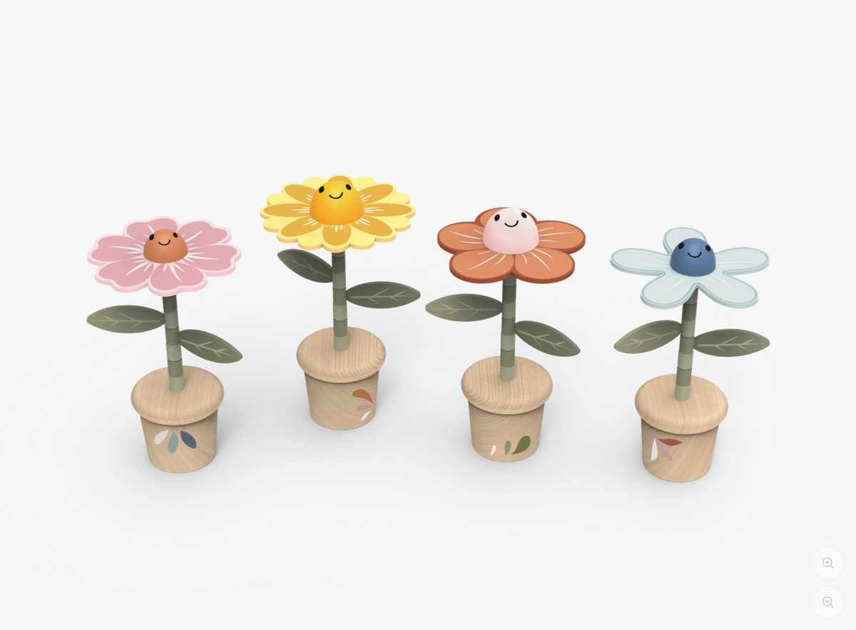 Four small wooden flower planters with smiling faces, shown on a clean white background. The flowers have pink, yellow, orange, and light blue petals, with green stems and leaves, and are planted in light wood pots.