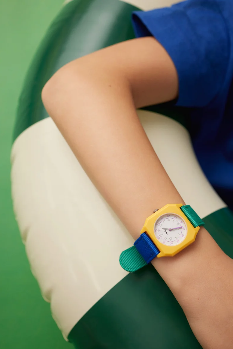 Colorful watch on a person's wrist with a green and white background