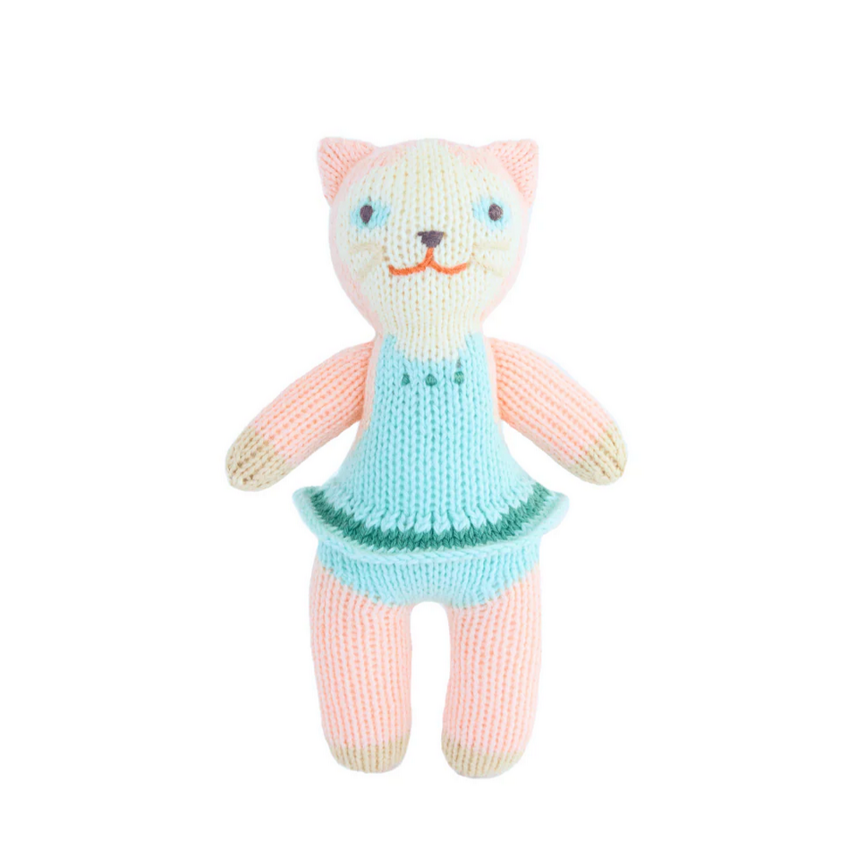 Knitted cat toy with a blue dress on a white background