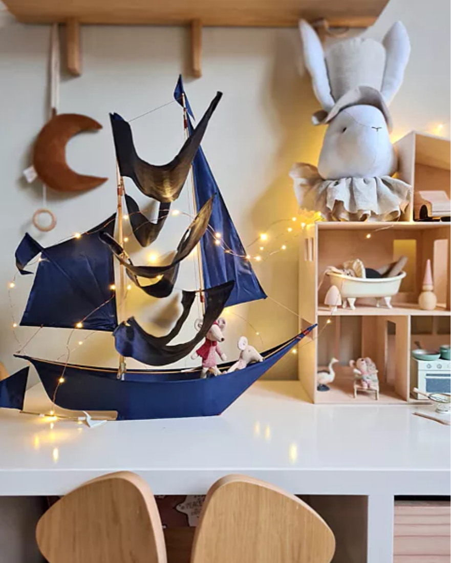 Decorative sailboat with lights on a shelf in a child's room
