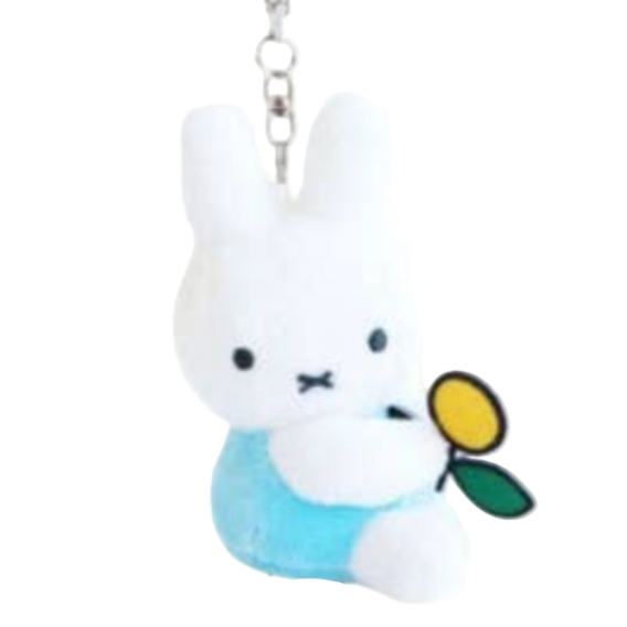 Two cartoon character keychains, one white and one brown, on a black background.