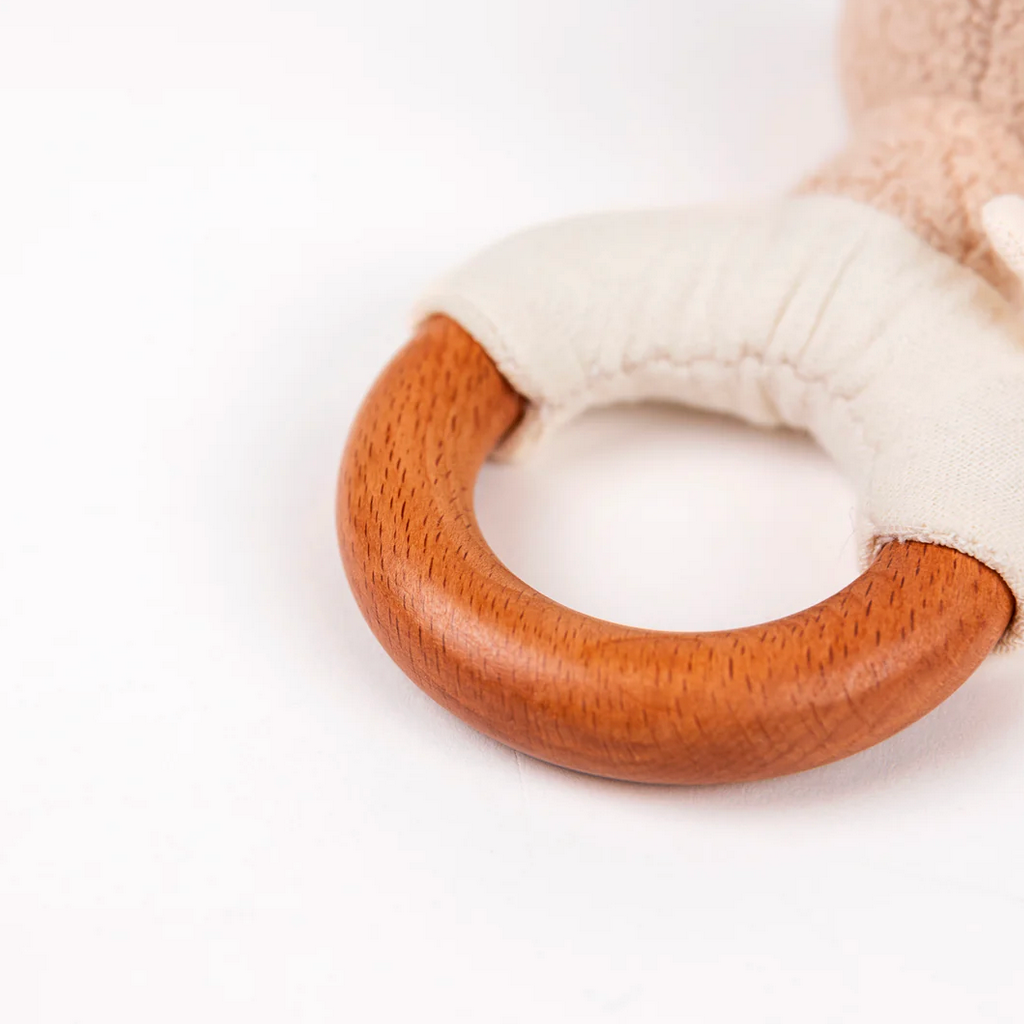 Wooden ring with white plush handle on a white background