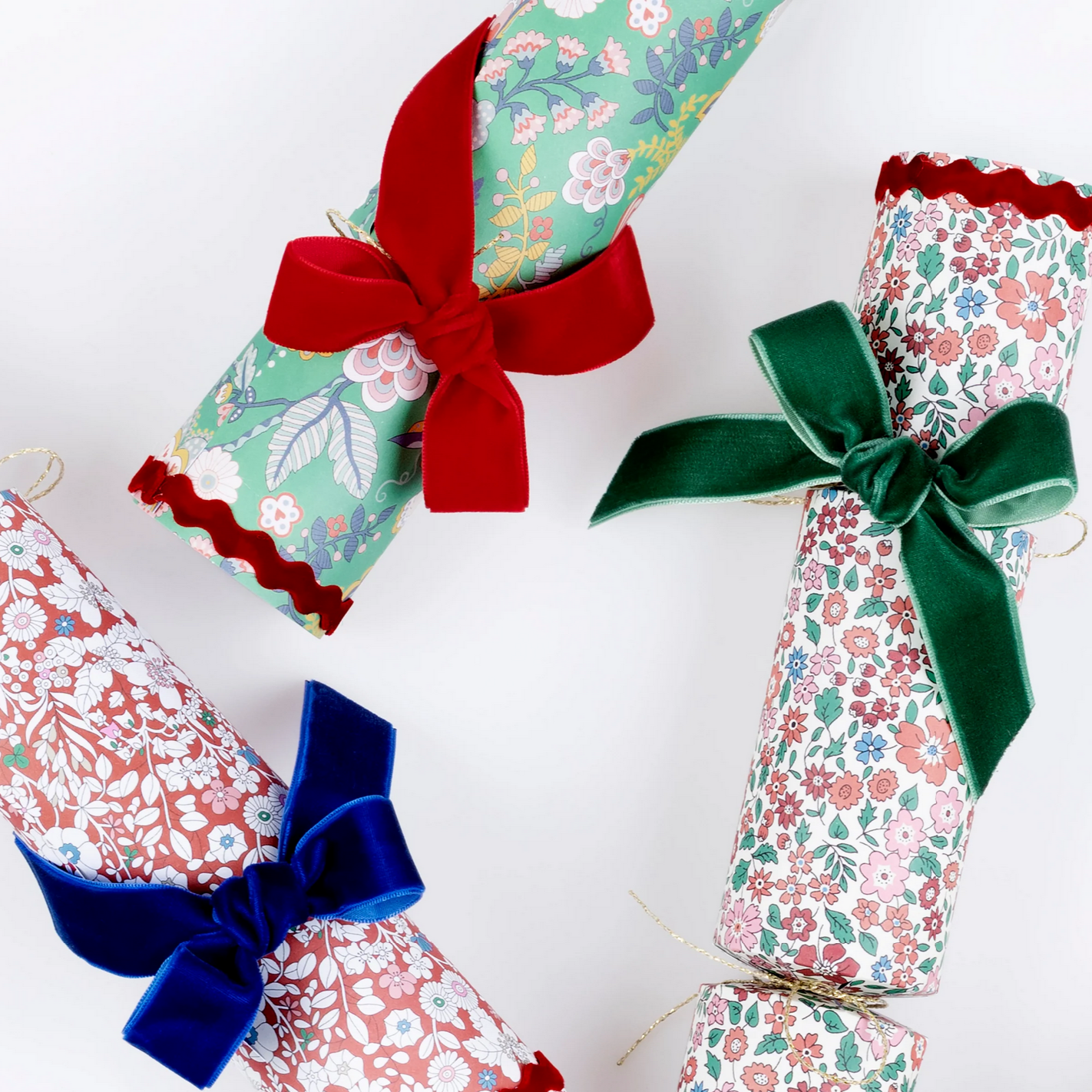 Decorative gift bags with floral patterns and colorful ribbons on a white background