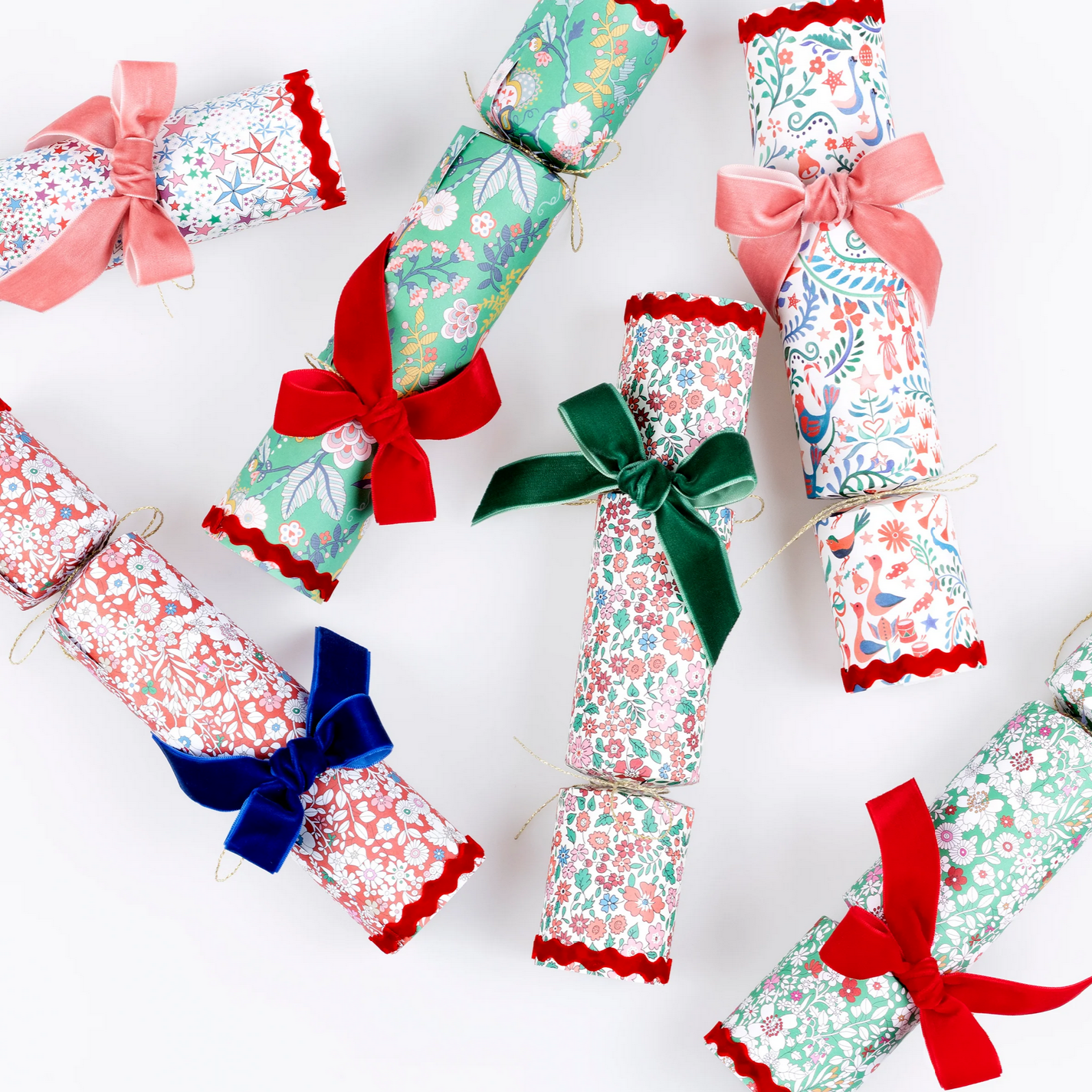 Decorative crackers with floral patterns and colorful bows on a white background