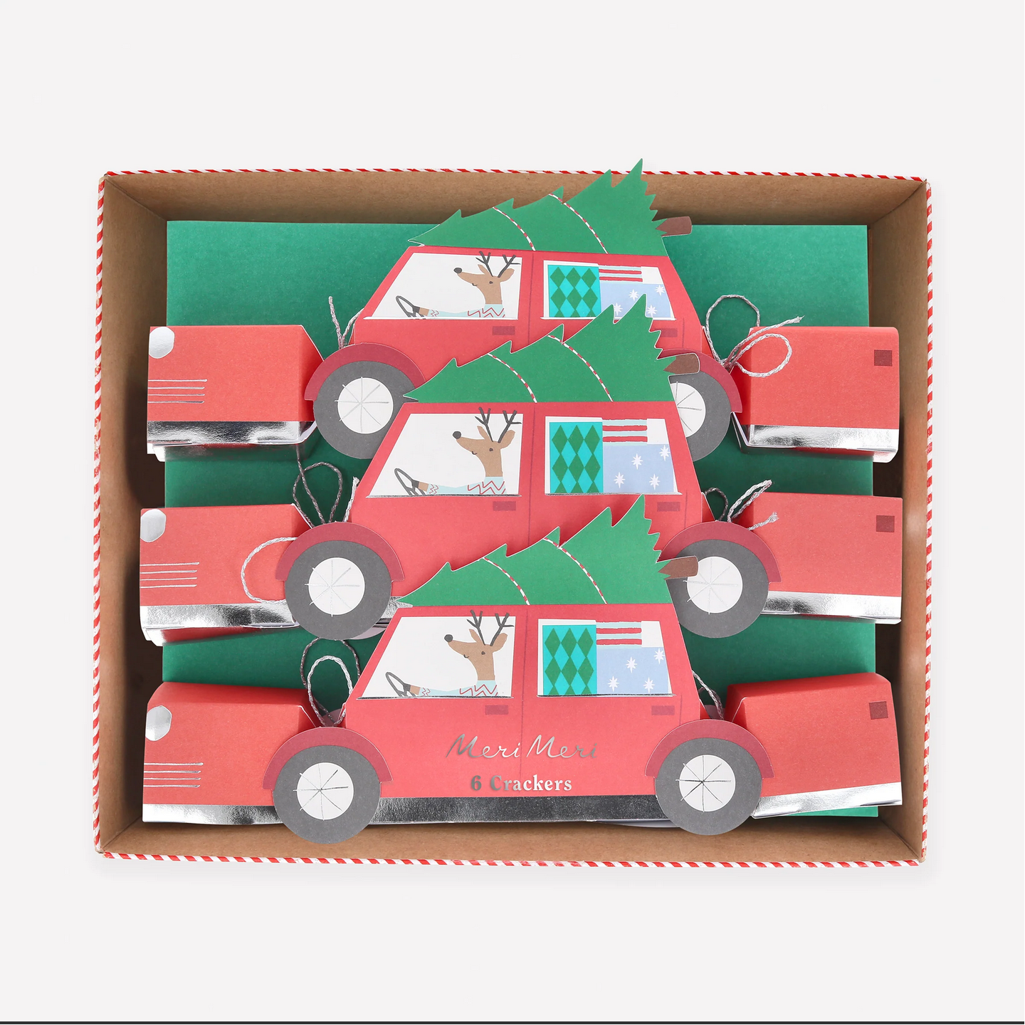 Box of red car-shaped crackers with green trees and deer on a white background