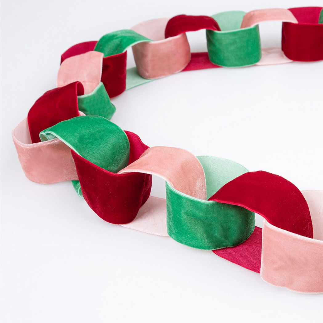 Colorful paper chain with red, green, and pink links on a white background