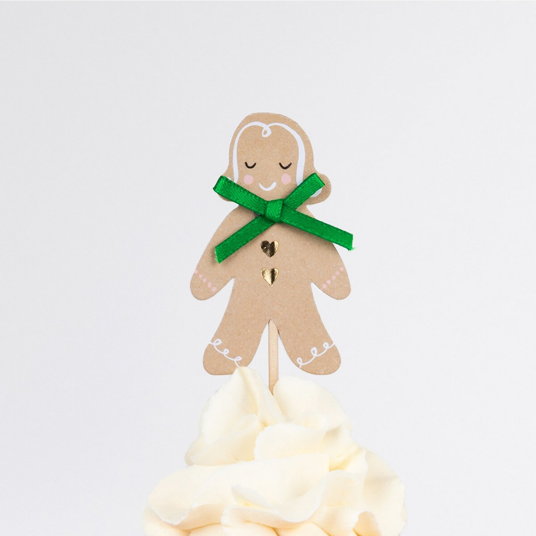 Gingerbread man decoration with a green ribbon on a white background