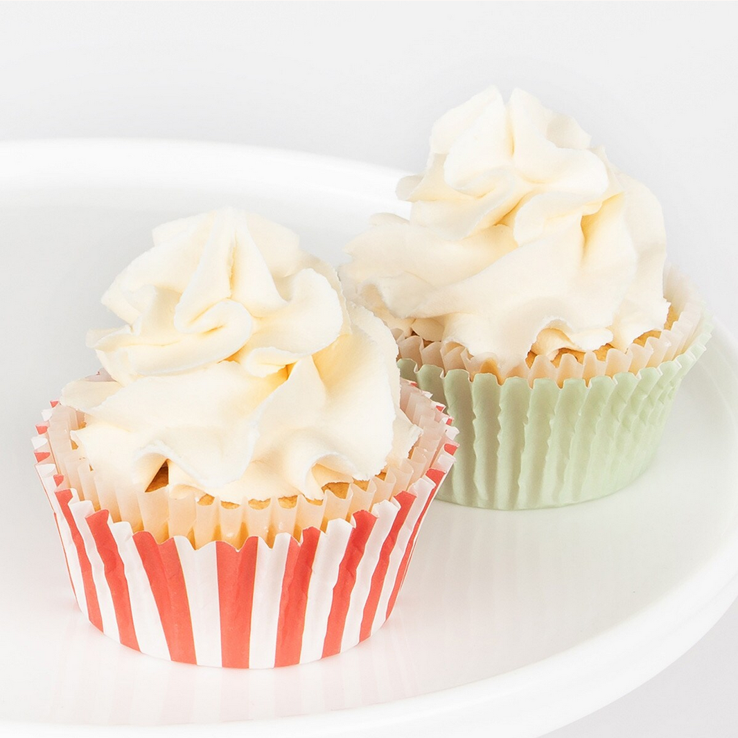 Two cupcakes with white frosting on a white plate