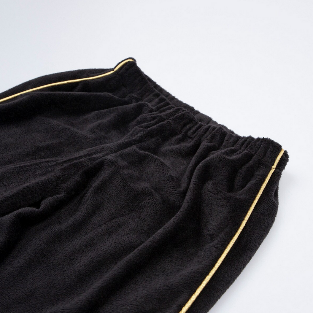 Black pants with gold piping on a white background