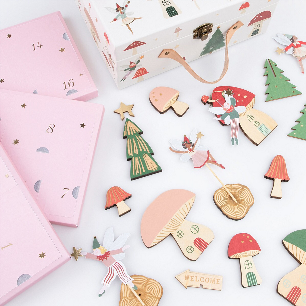 Wooden fairy and mushroom decorations with pink and white boxes on a white background