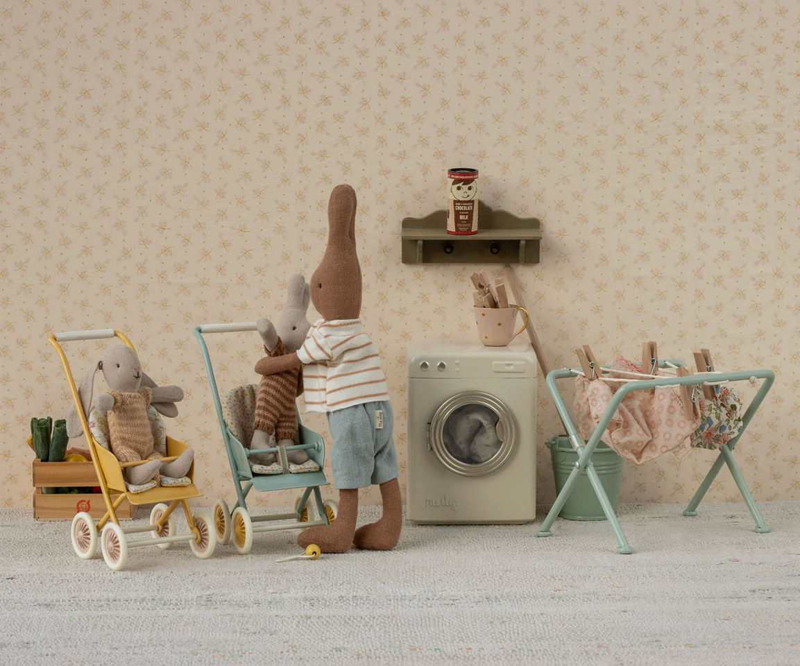 Children's playroom with toy washing machine, dryer, and shelves.