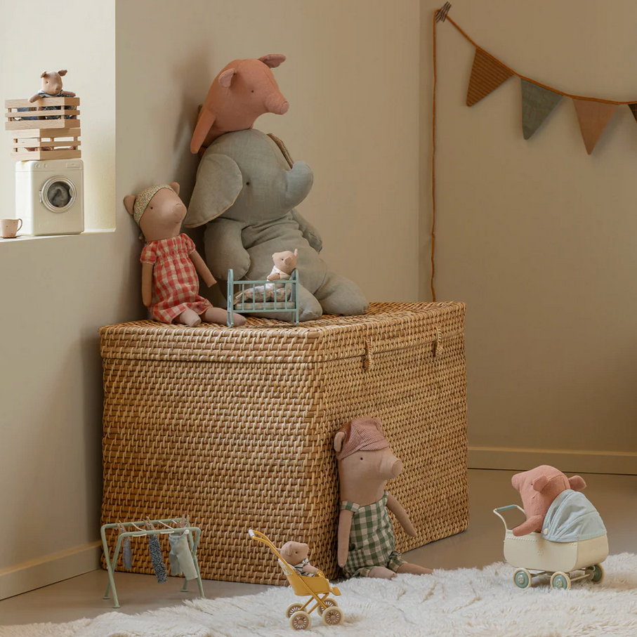 Children's room with toys and a wicker basket, featuring a banner on the wall.