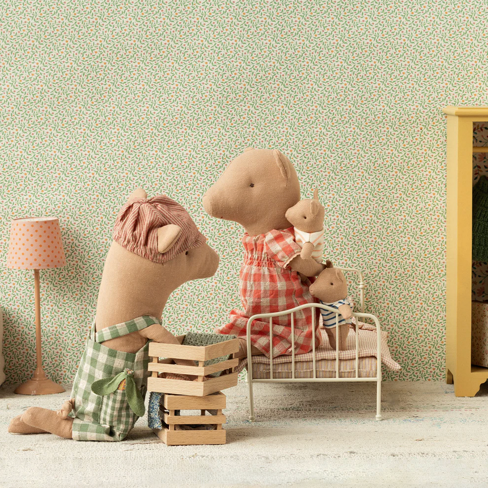 Stuffed animal toys in a room with a bed and lamp.