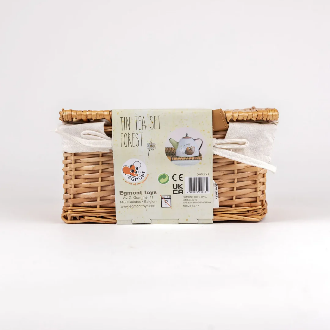 Wicker basket with a tea set and packaging label on a white background