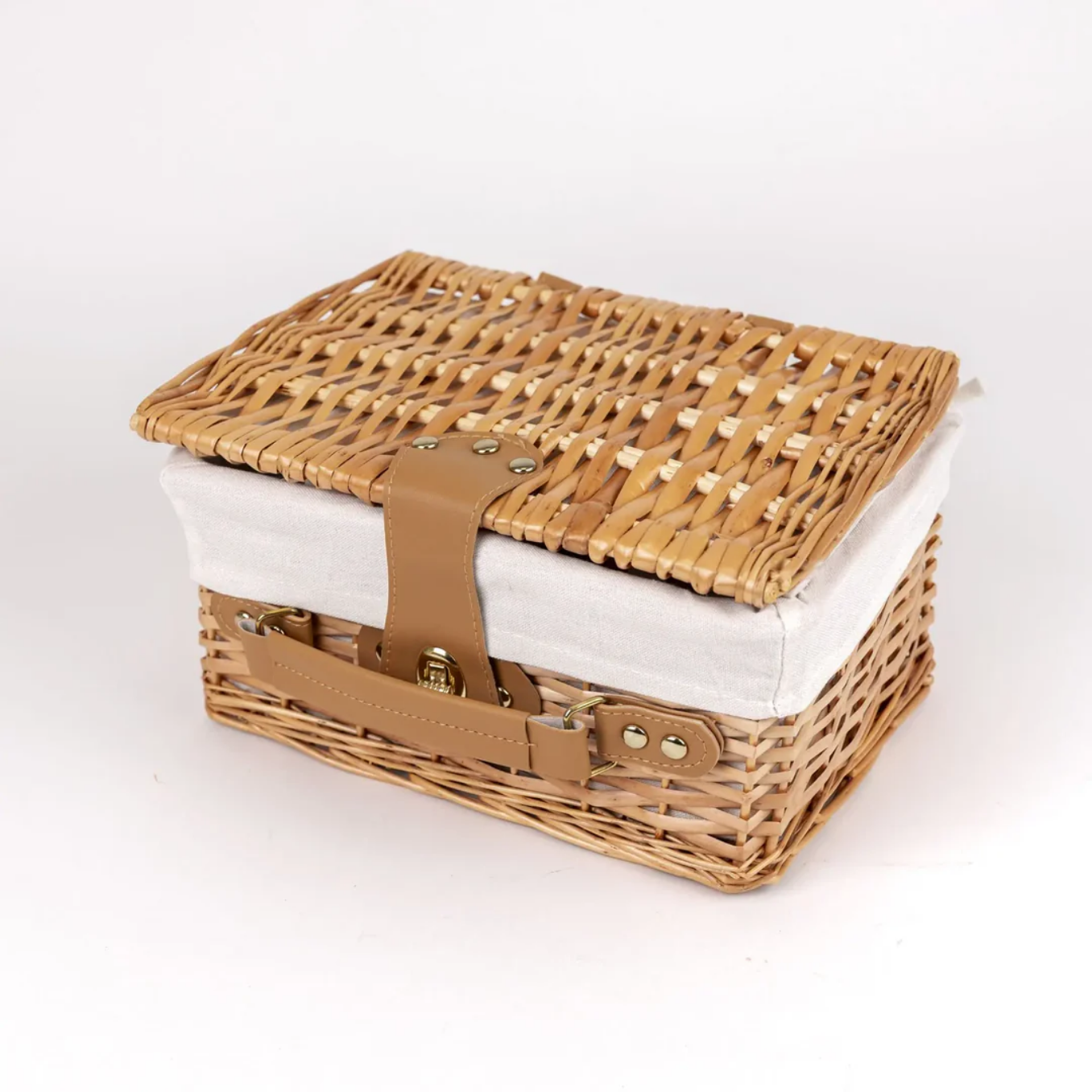 Wicker picnic basket with a white cushion on a light gray background